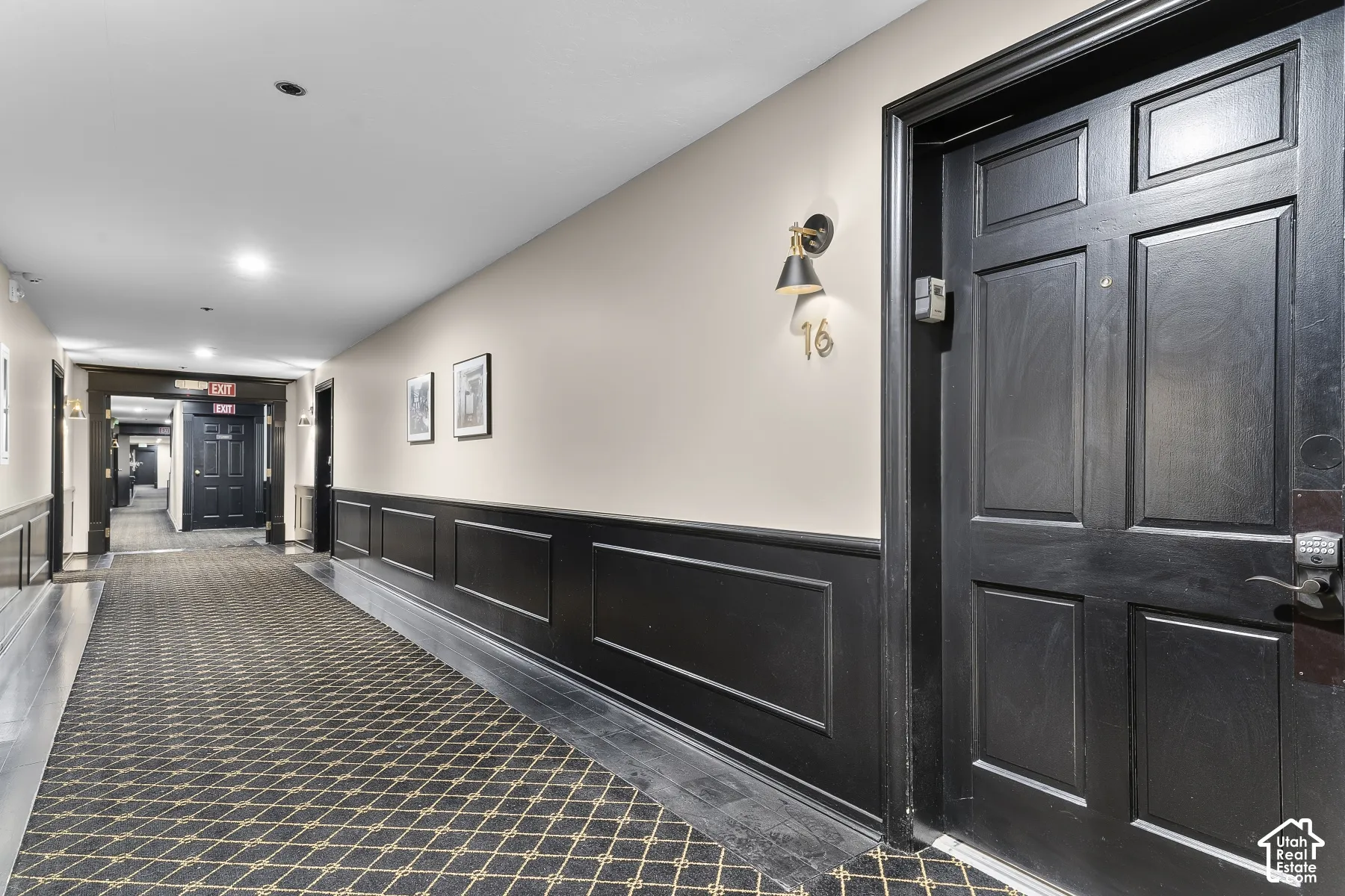 Corridor featuring wainscoting, recessed lighting, and patterned carpeting