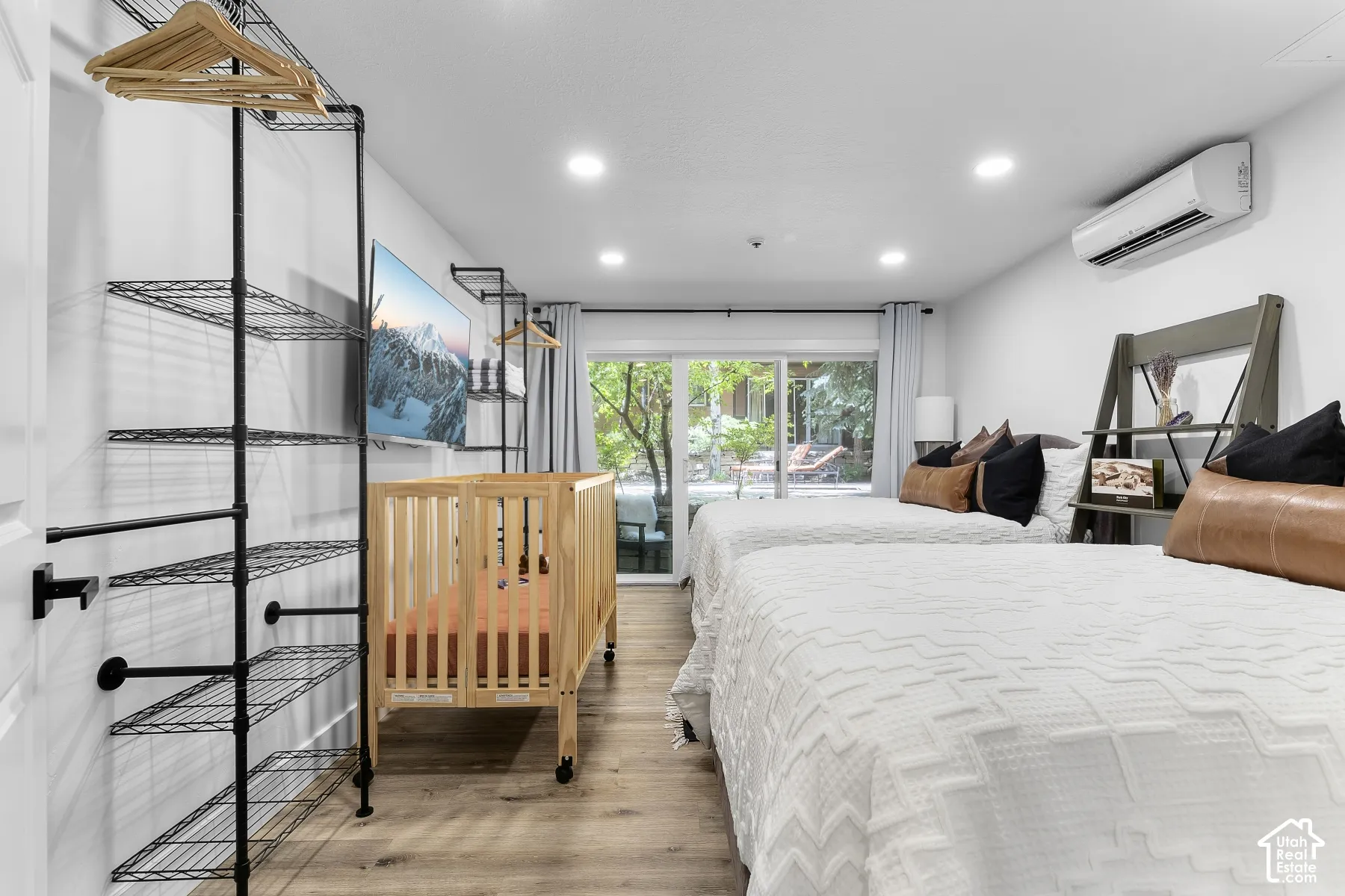 Recessed lighting, wood-finish flooring, glass sliding doors, and a wall-mounted mini-split system