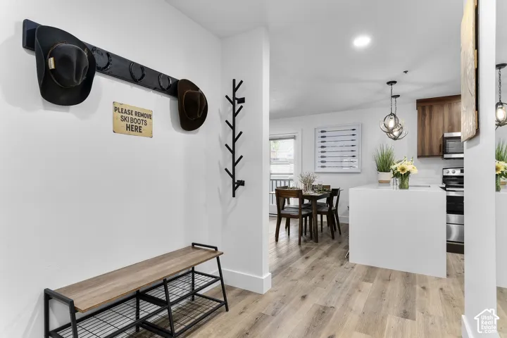 Wood-finish flooring throughout, white walls, and recessed lighting