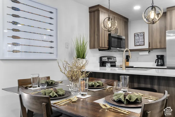 Kitchen featuring wood-finish cabinetry, white countertops, built-in microwave, and spherical pendant lighting