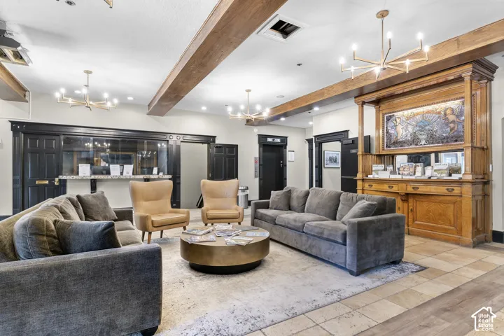 Tiled flooring with wood-finish accents, exposed beam ceiling details, recessed lighting, and ornate built-in cabinetry