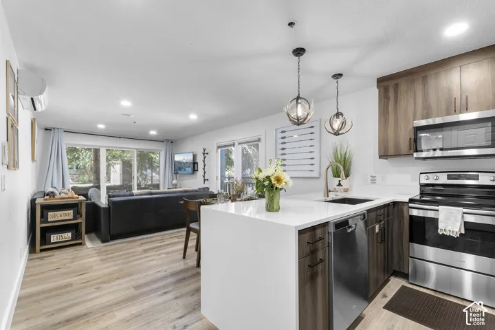 Open-concept living space featuring wood-finish flooring, recessed lighting, and large glass sliders