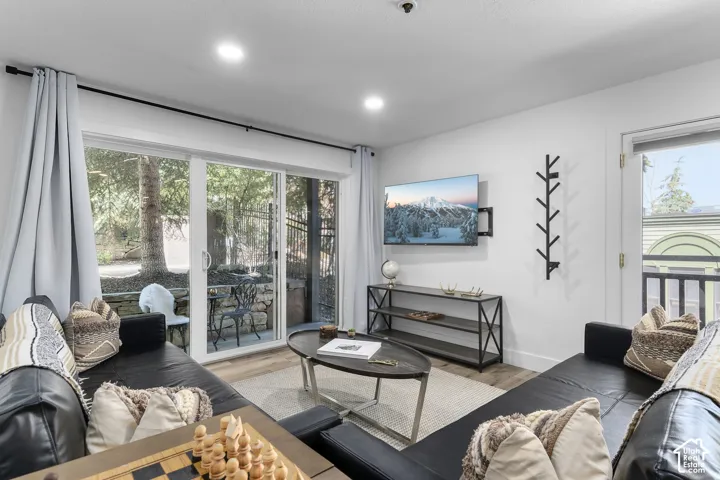 Living area with wood-finish flooring, recessed lighting, and sliding glass door access to an outdoor patio