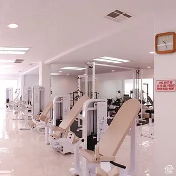 Fitness center featuring multiple weight machines, recessed lighting, and mirrored walls