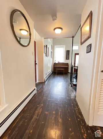 Hardwood flooring, painted white walls, and a ceiling-mounted light fixture