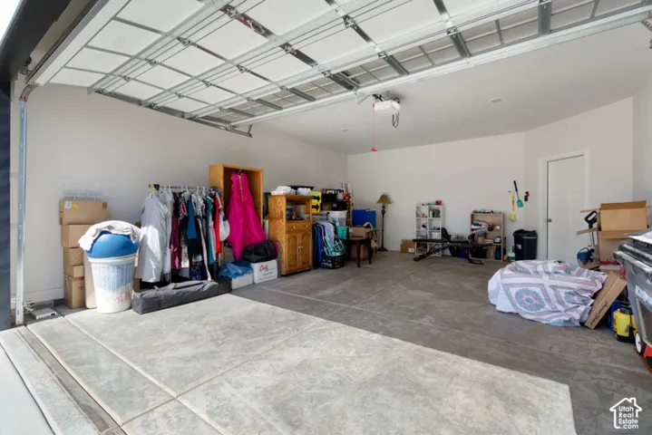 Spacious garage with a concrete floor, neutral wall paint, and an overhead garage door opener