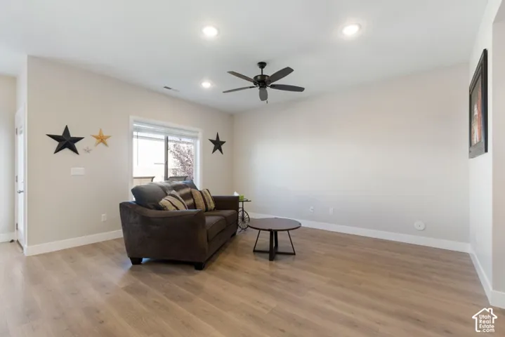 Spacious living area featuring wood-finish flooring, recessed lighting, and a ceiling fan