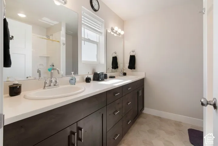 Dual vanity with white undermount sinks, chrome fixtures, and a light-toned countertop