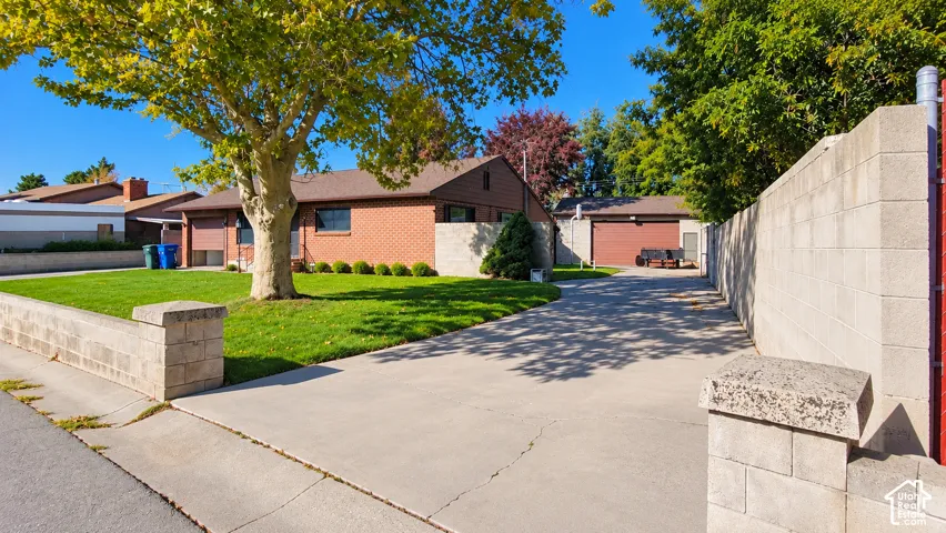 Brick exterior residence featuring a concrete driveway and an attached garage with a red door