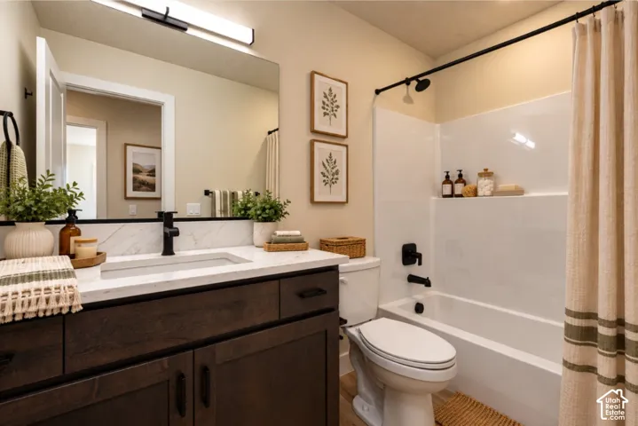 Wood-finish vanity with a light-toned countertop, rectangular sink, and matte black faucet