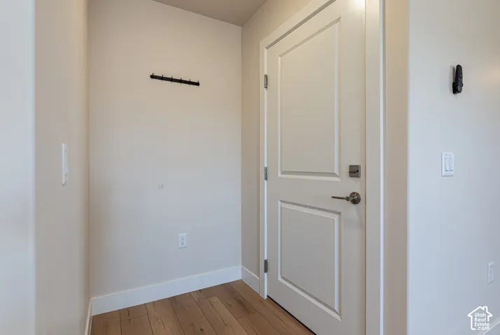 White interior door with brushed nickel hardware and wood-finish flooring