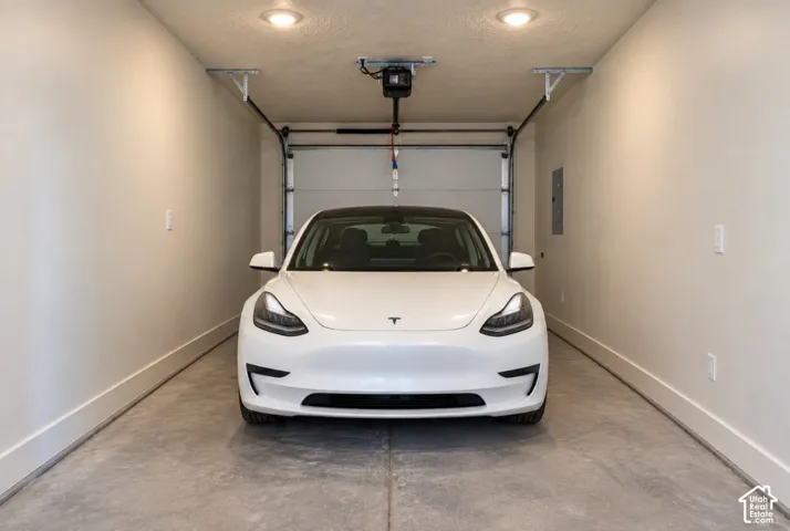 Attached garage with a concrete floor, recessed lighting, and an automatic garage door opener