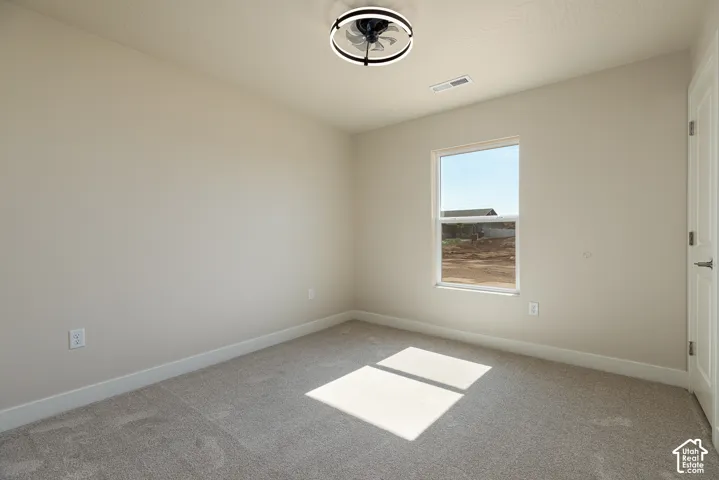 Recessed window with white trim, light neutral wall paint, gray carpet, and a modern ceiling fan with integrated lighting