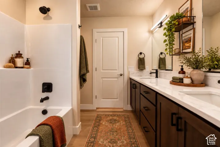 Dual vanity with undermount sinks, wood-finish cabinetry, and white countertops