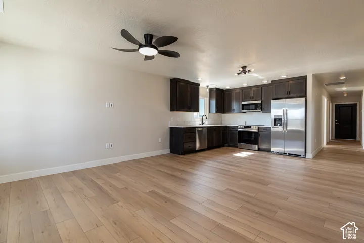 Open-concept living space featuring wood-finish flooring and a ceiling fan