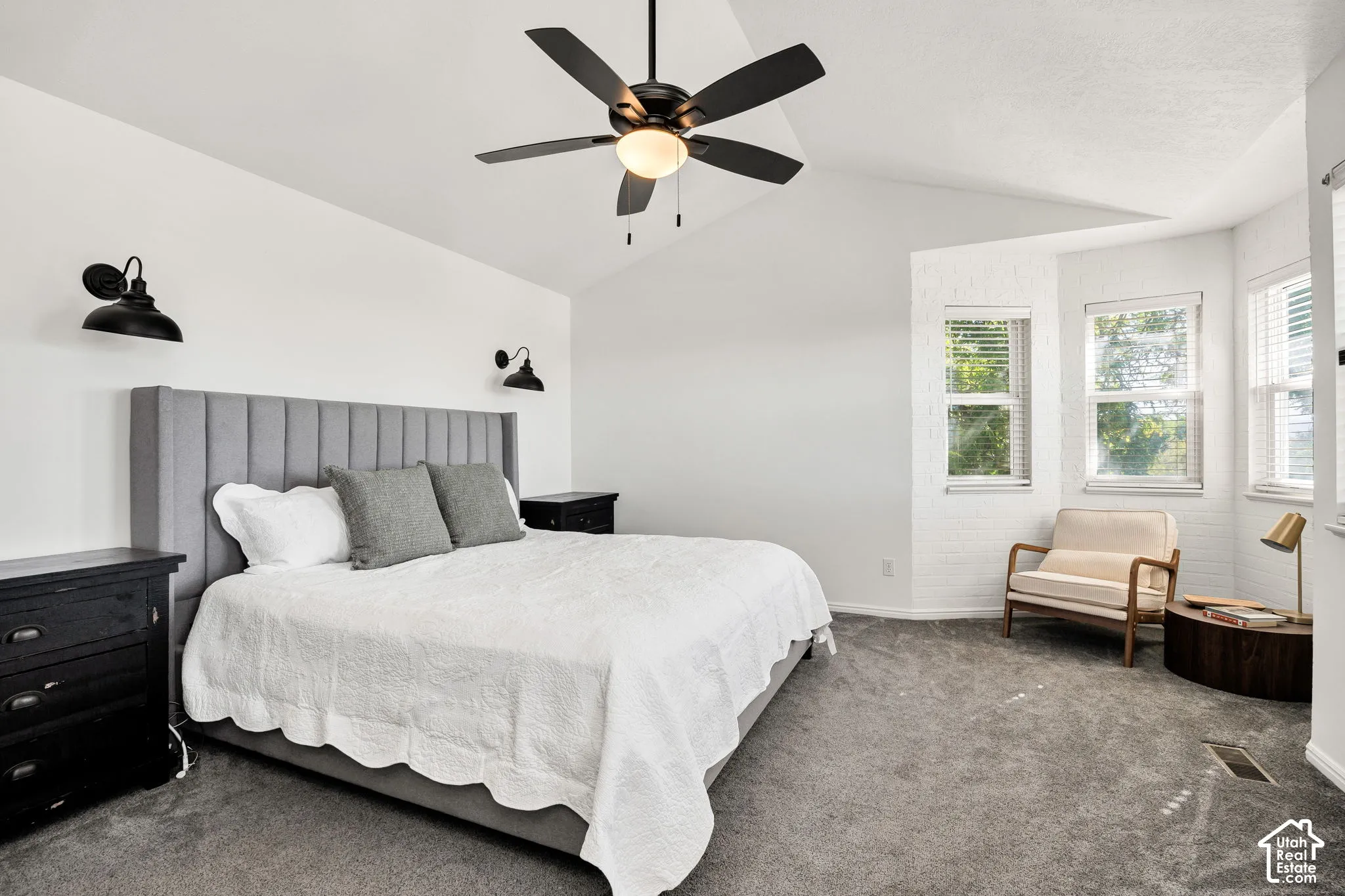 Ensuite vaulted ceiling with a ceiling fan, plush carpeting, built-in vanity.