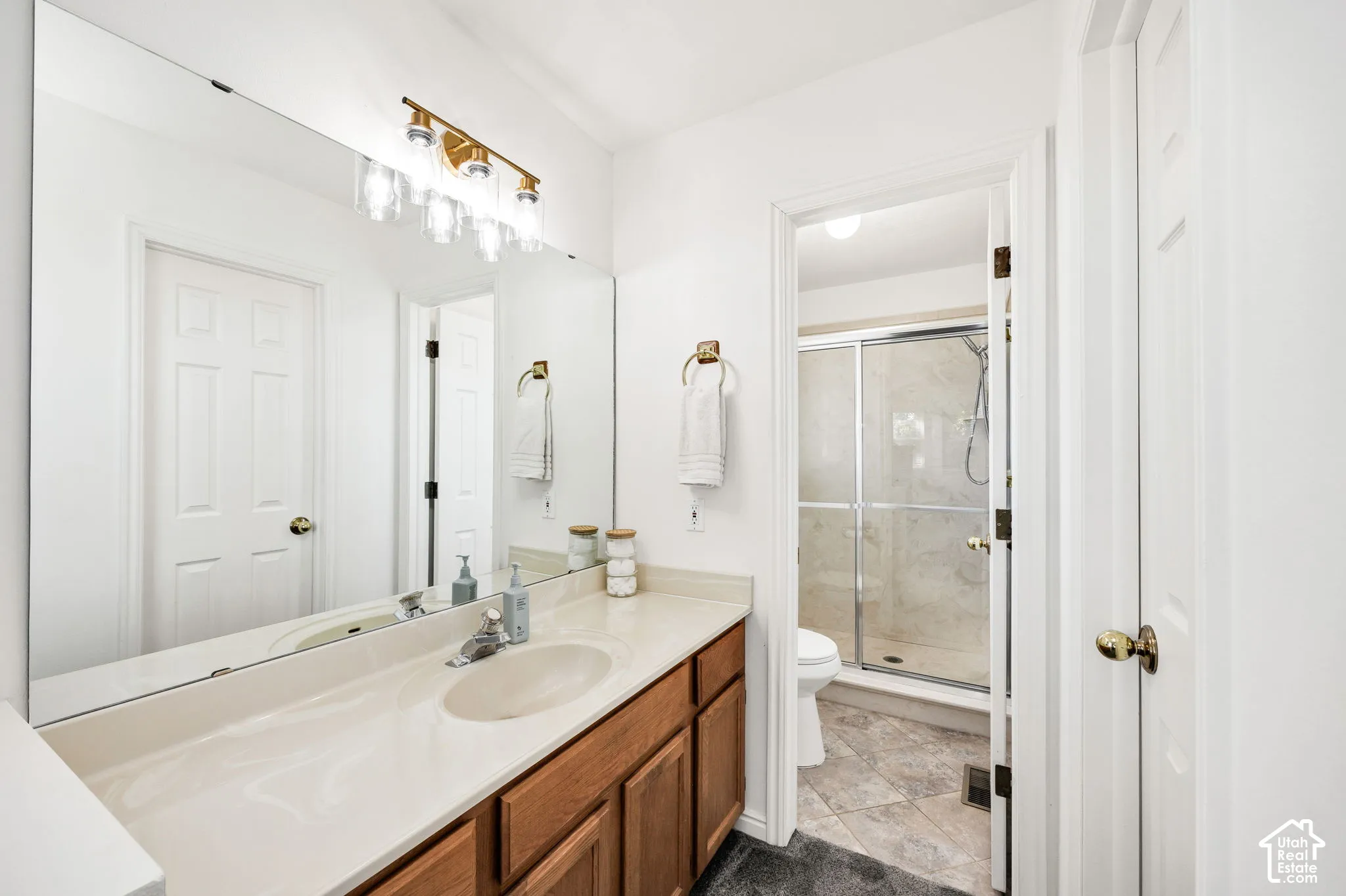 Ensuite vaulted ceiling with a ceiling fan, plush carpeting, built-in vanity.