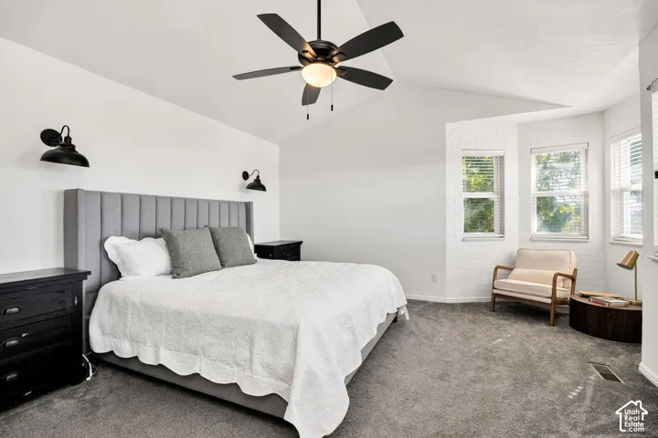 Ensuite vaulted ceiling with a ceiling fan, plush carpeting, built-in vanity.
