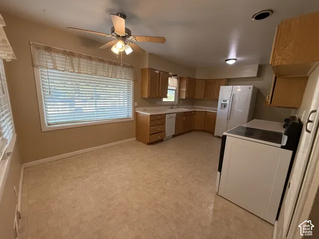 Kitchen featuring wood-finish cabinetry, white countertops, a ceiling fan, and tile-look flooring