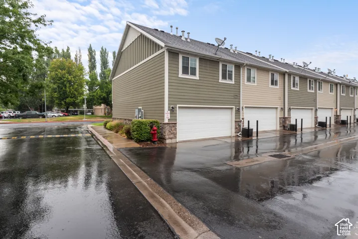 Row of attached residences featuring multiple garage doors and varied siding colors
