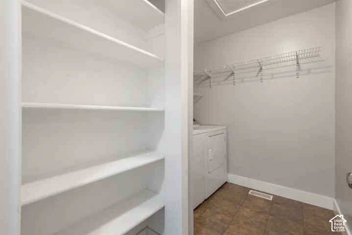 Dedicated laundry space featuring a white dryer and wire shelving