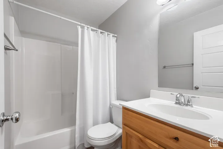 Wood-finish vanity with white countertop, chrome faucet, and integrated sink