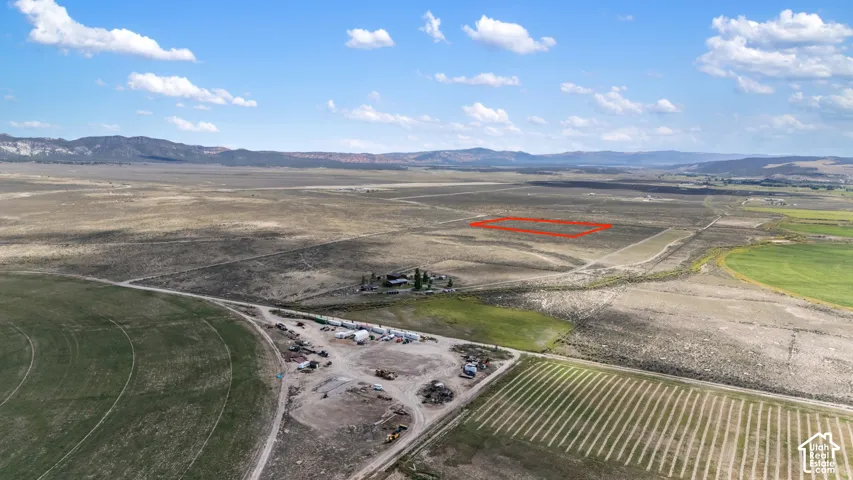 Expansive open land with varied terrain, surrounded by distant mountains