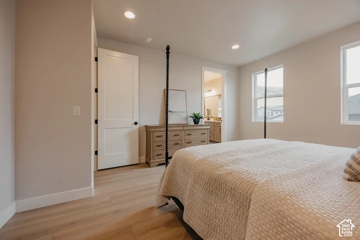 Neutral-toned interior featuring wood-finish flooring, recessed lighting, and white shaker-style doors