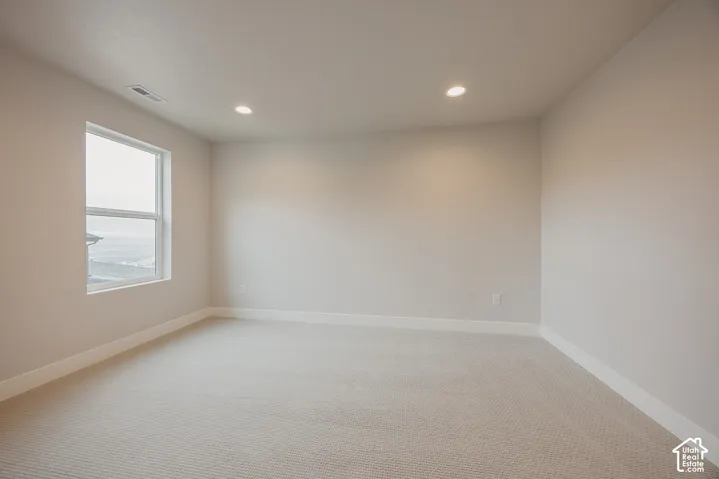 Neutral wall finishes, recessed ceiling lighting, single-pane window, and wall-to-wall carpeting