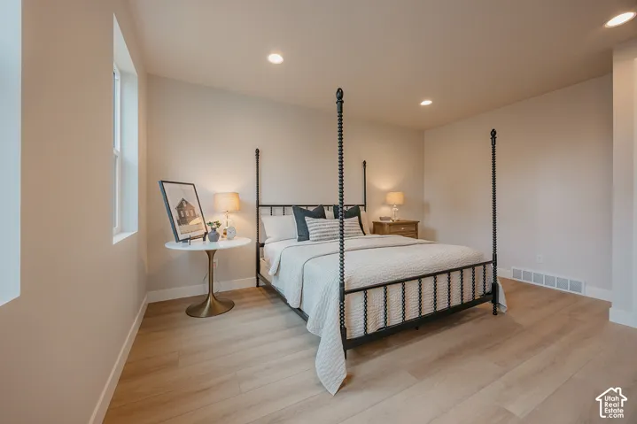 Neutral-toned interior space featuring wood-finish flooring, recessed lighting, and large windows