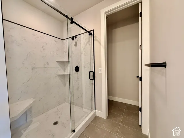 Glass-enclosed shower with a black-finish sliding door and integrated seating