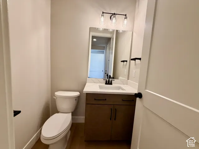 Vanity with a quartz countertop, integrated sink, and wood-finish cabinetry