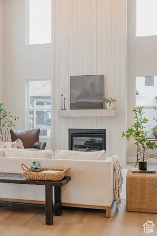 Floor-to-ceiling vertical plank detailing, fireplace with a thick stone mantle, and expansive multi-level windows