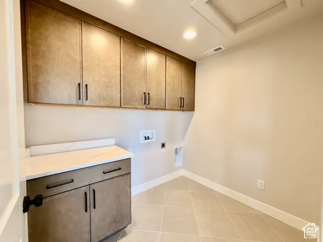 Extensive upper cabinetry, lower cabinetry with integrated countertop, tiled flooring, recessed lighting, and a ceiling access panel