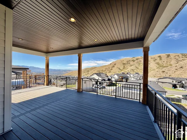 Covered outdoor deck with composite decking, recessed lighting, and black metal railings