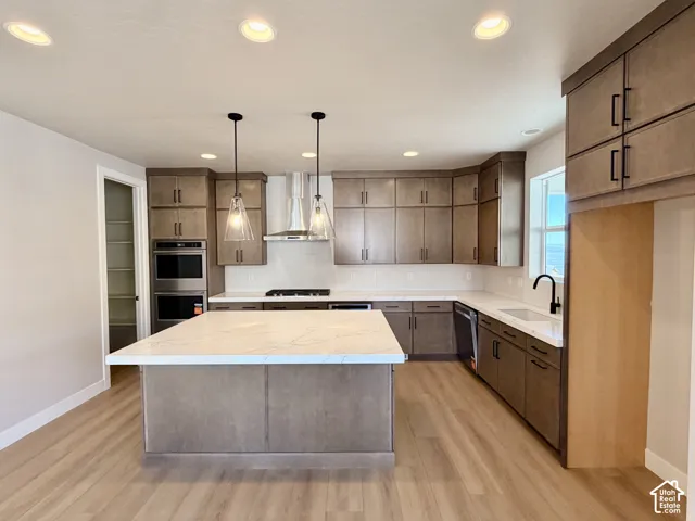 Kitchen featuring a large central island, coordinating cabinetry, white countertops, and wood-finish flooring
