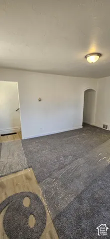 Freshly painted white walls, textured ceilings, recessed lighting, and an arched entryway