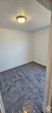 Recessed wall access panel, white painted walls, textured ceiling, flush mount ceiling light, and gray patterned carpeting