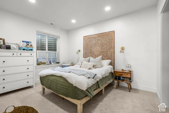 Recessed lighting illuminates the space, featuring a window with integrated blinds