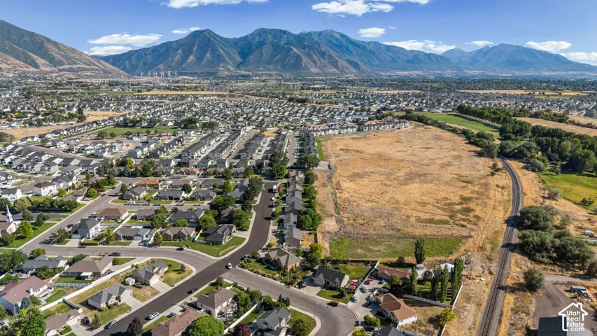 Expansive land parcel with surrounding residential areas and a prominent mountain backdrop