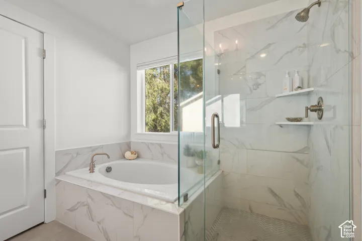 Walk-in shower with clear glass enclosure and chevron-patterned tile flooring
