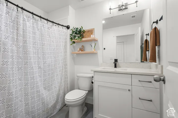 White vanity with a light-colored countertop, undermount sink, and black faucet
