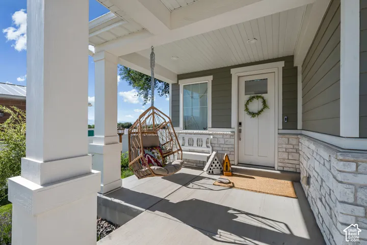 Covered front porch featuring white columns and a beadboard ceiling