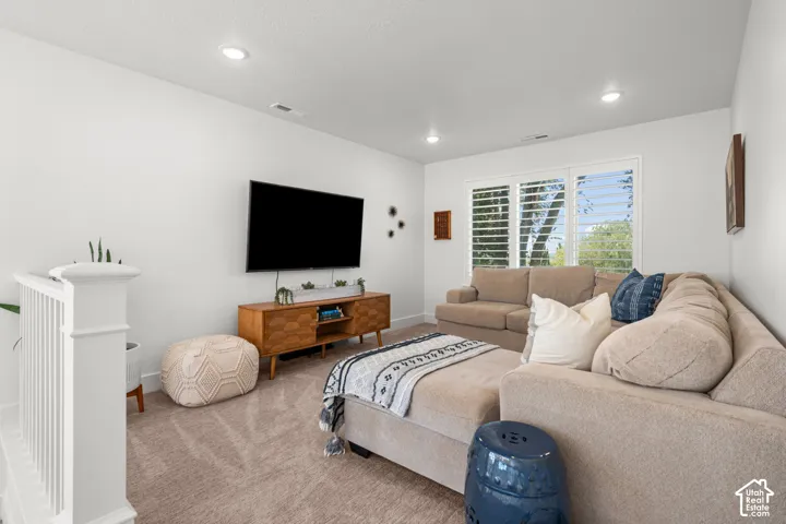 Recessed lighting illuminates the space, featuring a window with plantation shutters