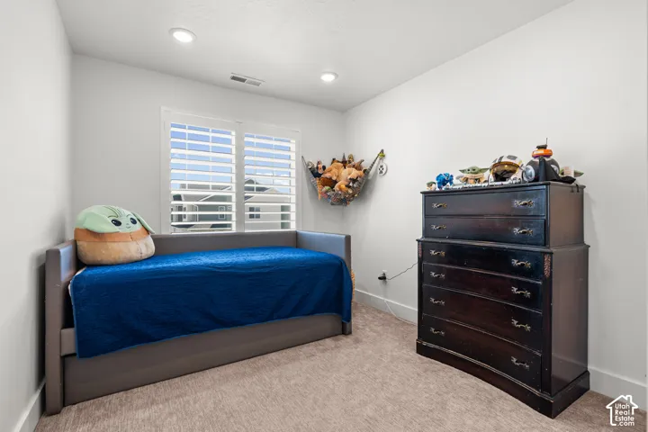 Recessed lighting illuminates neutral-toned walls and plush carpeting