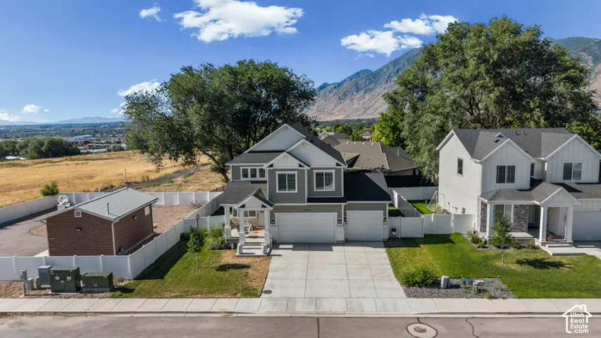 Two-story exterior with a covered entry, attached two-car garage, concrete driveway, and front lawn