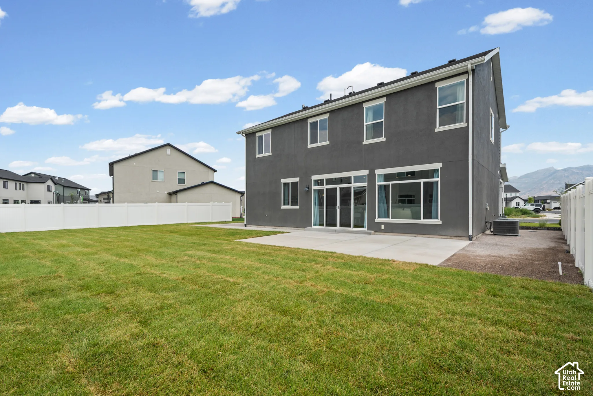 Expansive green lawn with a concrete patio