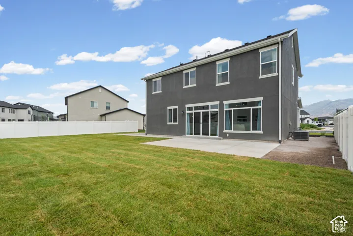 Expansive green lawn with a concrete patio