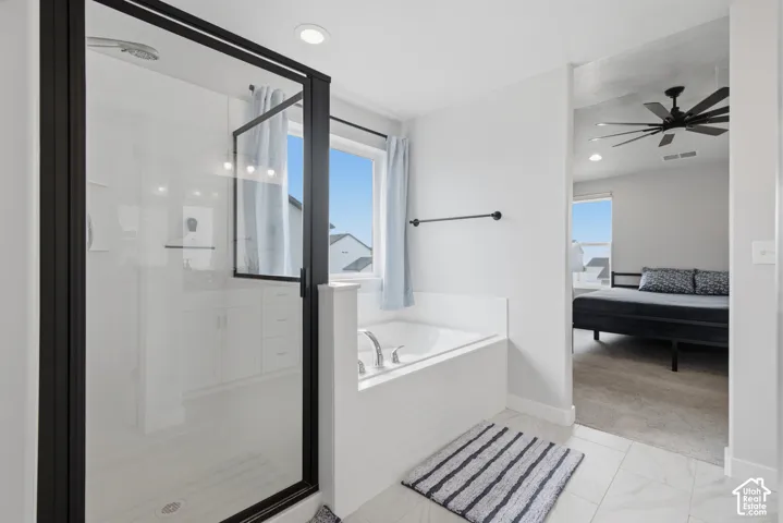 Glass-enclosed shower with black framing, built-in soaking tub, window above the tub, recessed lighting, and tile flooring