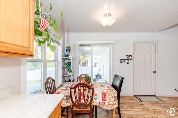 White paneled door, wood-finish flooring, white window frames, and sliding glass door